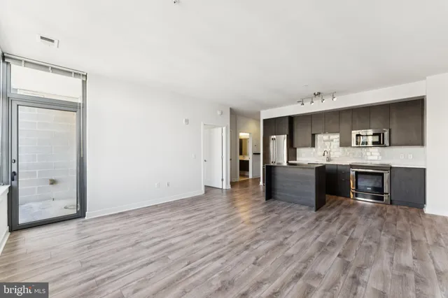 a room with a bed and a kitchen view