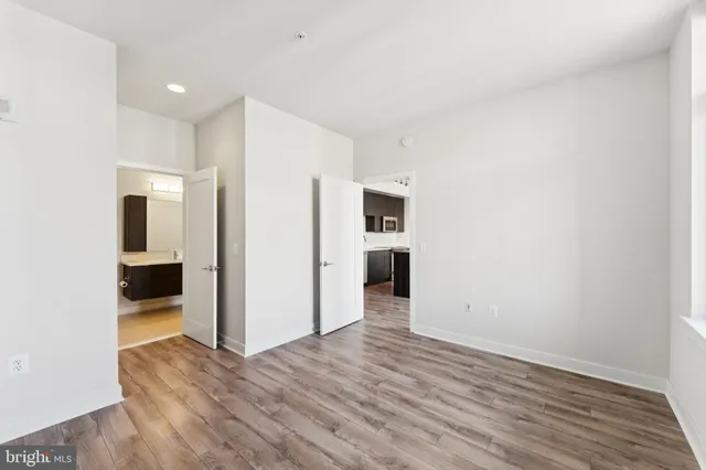 a view of empty room with wooden floor
