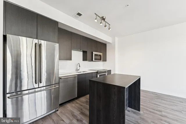 a kitchen with stainless steel appliances a refrigerator and a sink