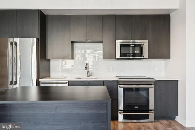 a kitchen with appliances a sink and cabinets
