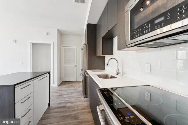 a kitchen with a sink and a stove top oven