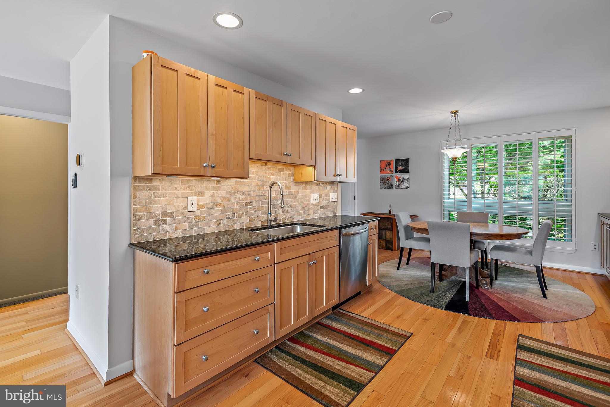 7261 Dockside Lane Columbia, MD 21045 - Photo 17 of 68 a kitchen with stainless steel appliances granite countertop a table chairs sink and cabinets