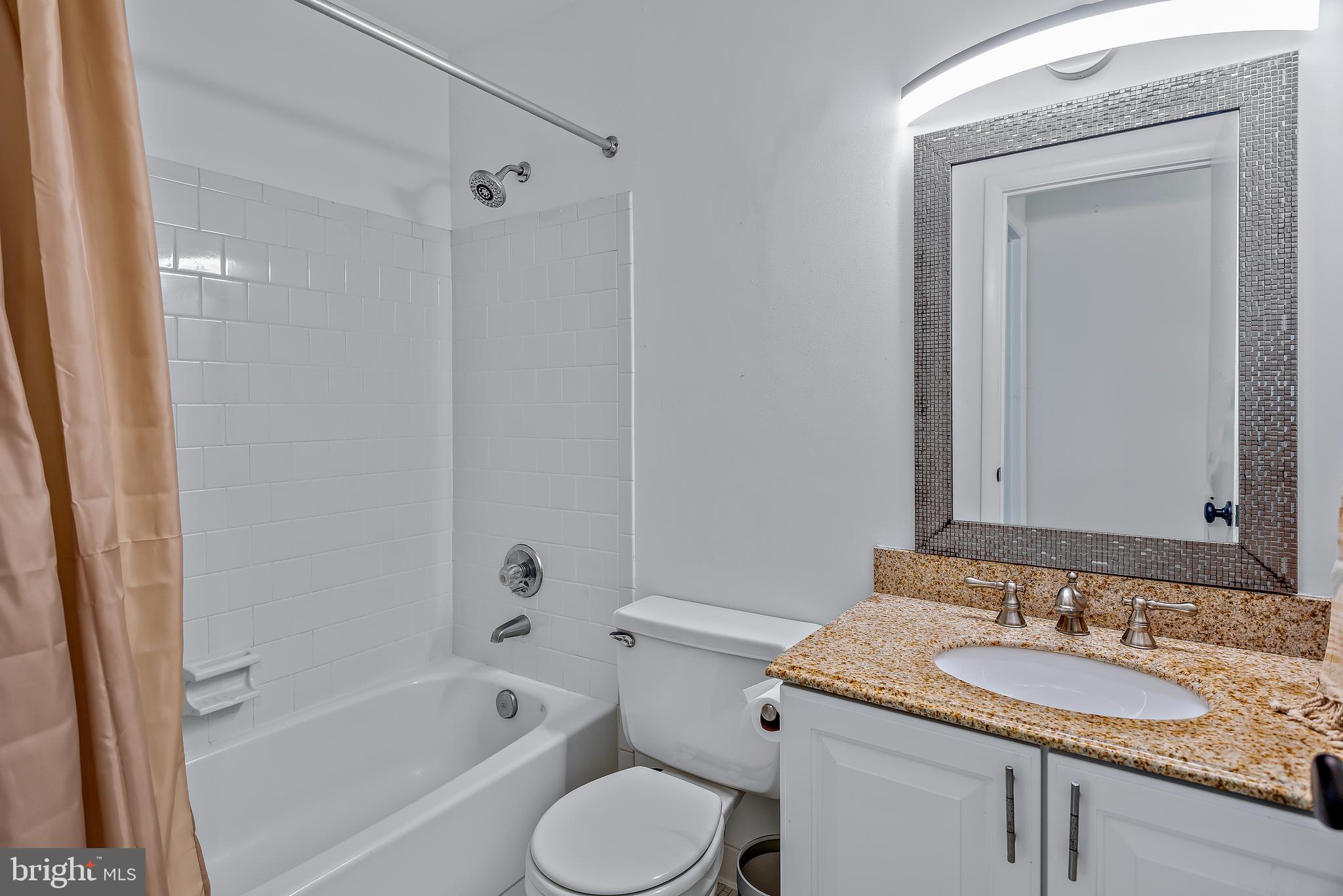 7261 Dockside Lane Columbia, MD 21045 - Photo 42 of 68 a bathroom with a granite countertop sink toilet and shower