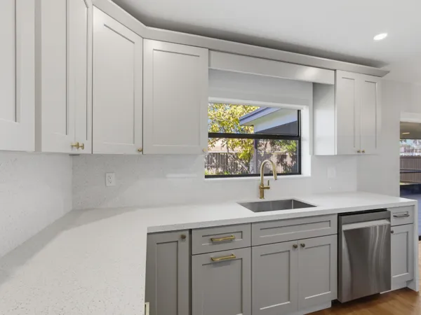 a kitchen with stainless steel appliances white cabinets and a window
