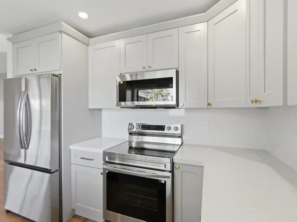 a kitchen with stainless steel appliances a stove microwave and refrigerator