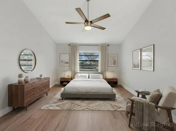 a spacious bedroom with a bed a window and a chandelier