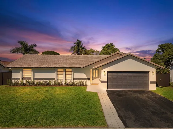 a front view of a house with a garden