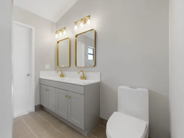 a bathroom with a toilet sink and mirror