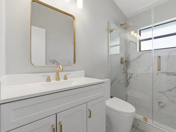 a bathroom with a sink a toilet and shower