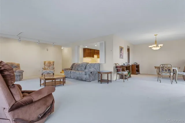 a living room with furniture and a dining table with chairs