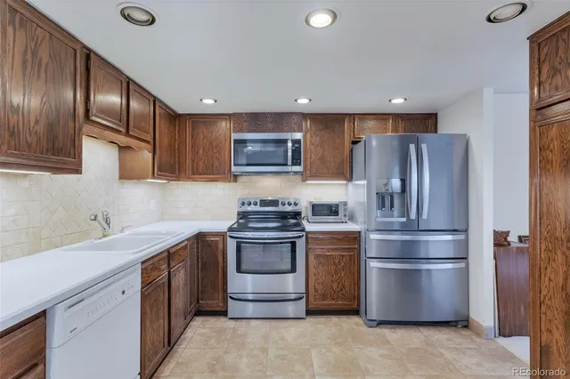 a kitchen with stainless steel appliances granite countertop a refrigerator stove and sink