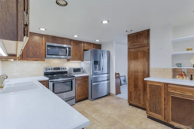 a kitchen with stainless steel appliances granite countertop a refrigerator stove and sink