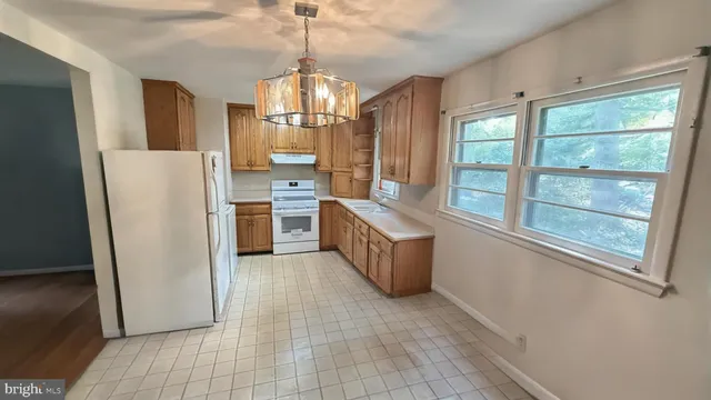 a view of a kitchen with a refrigerator stove wooden floor and a kitchen