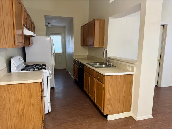 a kitchen with stainless steel appliances a stove top oven a sink a counter space and cabinets