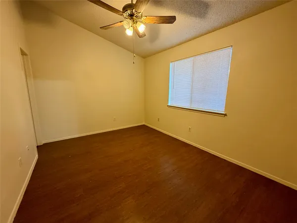 an empty room with a window and a fan