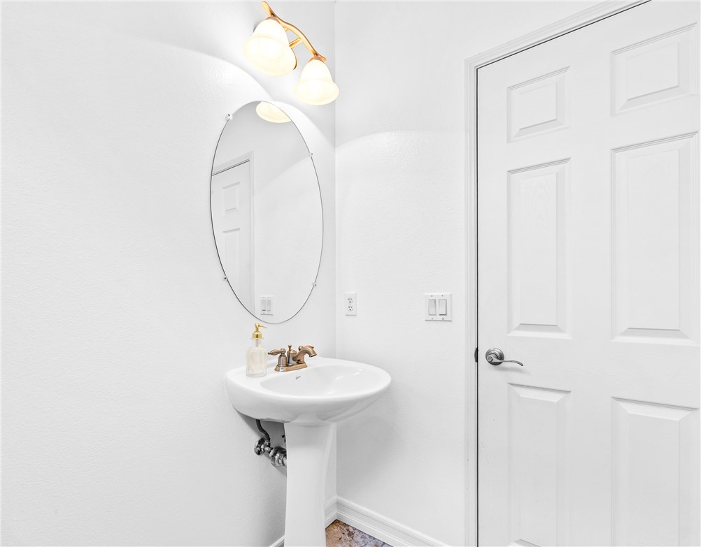 6310 Cosmos Street Eastvale, CA 92880 - Photo 11 of 71 a bathroom with a sink a mirror and a shower