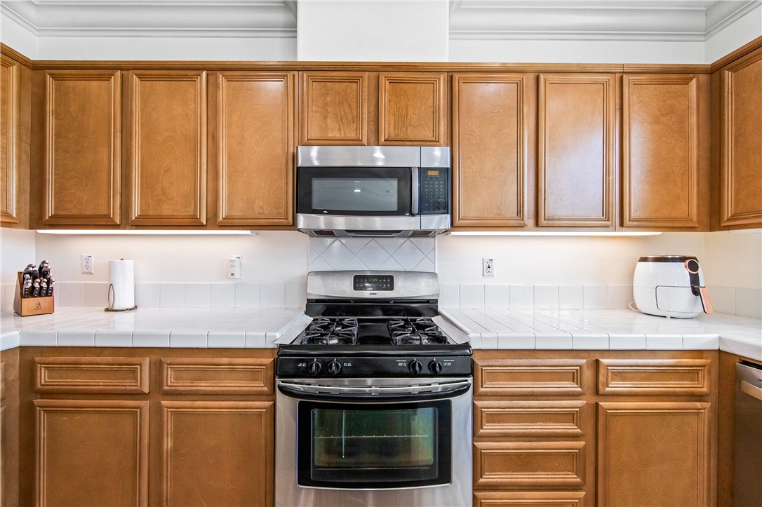6310 Cosmos Street Eastvale, CA 92880 - Photo 28 of 71 a kitchen with granite countertop a stove sink and microwave