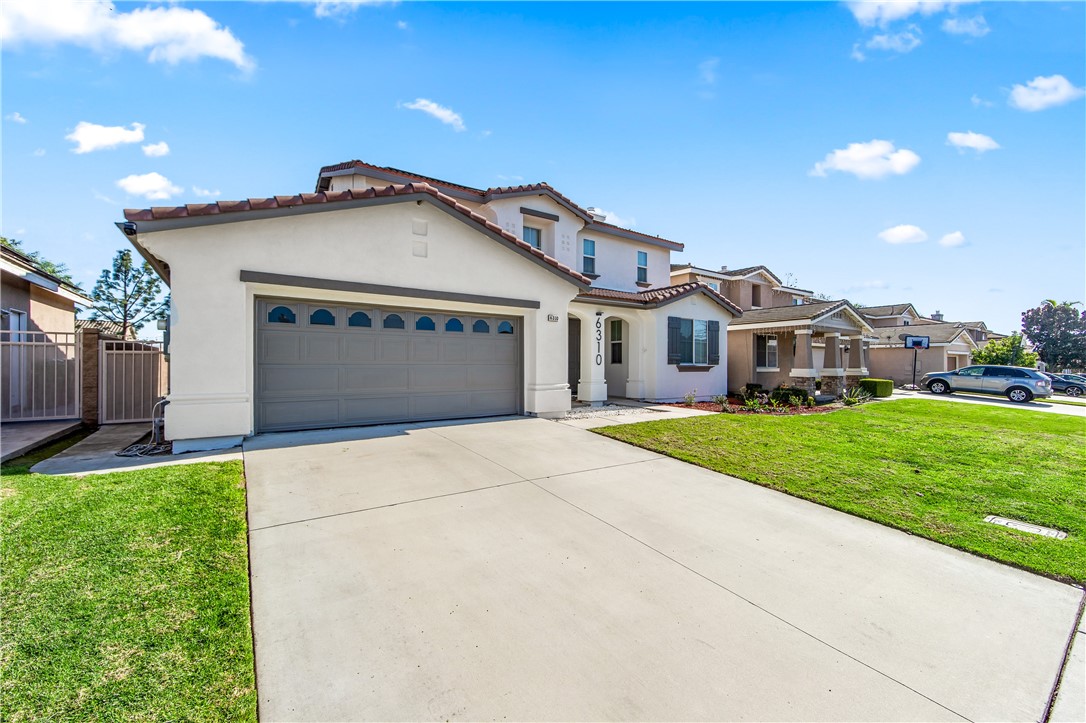 6310 Cosmos Street Eastvale, CA 92880 - Photo 3 of 71 a front view of a house with a yard and garage