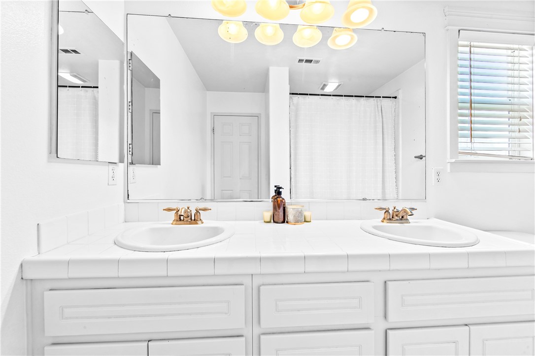 6310 Cosmos Street Eastvale, CA 92880 - Photo 44 of 71 a bathroom with double vanity and a mirror
