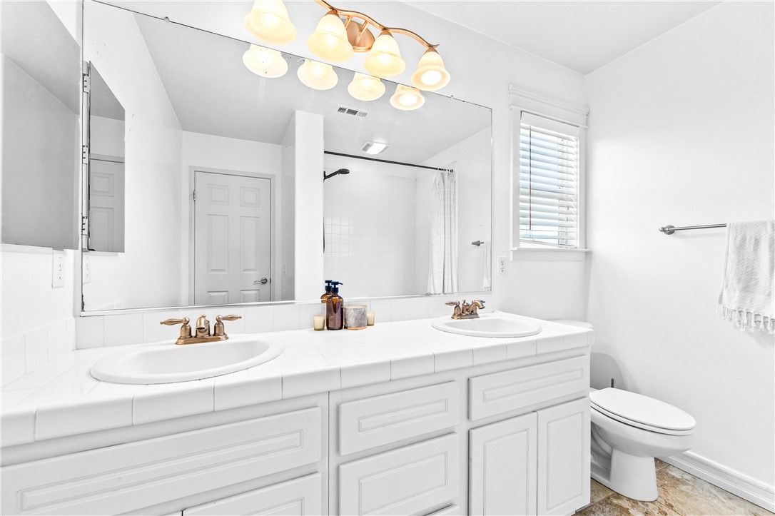 6310 Cosmos Street Eastvale, CA 92880 - Photo 47 of 71 a bathroom with a sink a toilet and a mirror