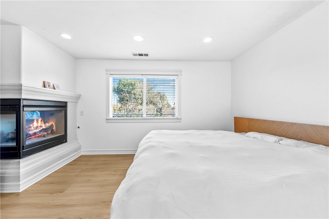 6310 Cosmos Street Eastvale, CA 92880 - Photo 53 of 71 a bedroom with a bed and a fireplace