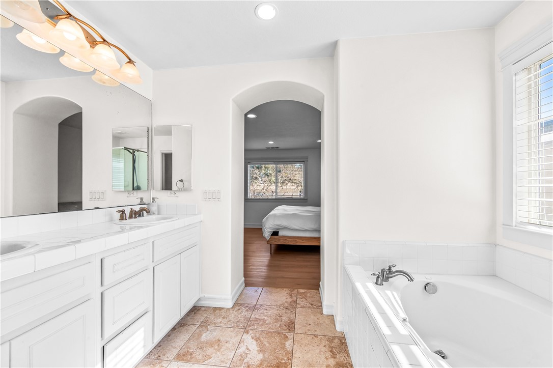 6310 Cosmos Street Eastvale, CA 92880 - Photo 57 of 71 a en suite spacious bathroom with a tub sink and mirror
