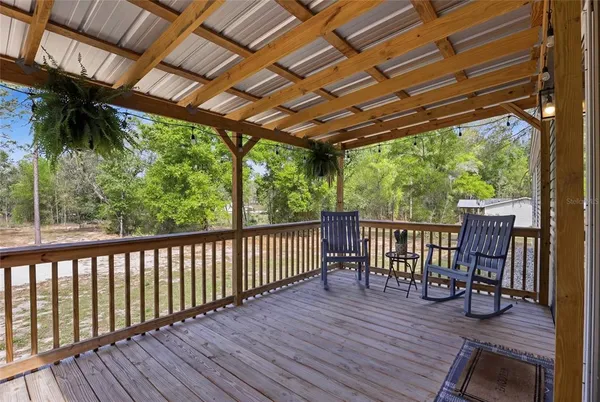 a view of a patio with table and chairs and wooden floor