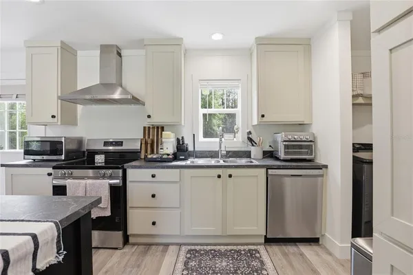 a kitchen with stainless steel appliances a sink stove and refrigerator