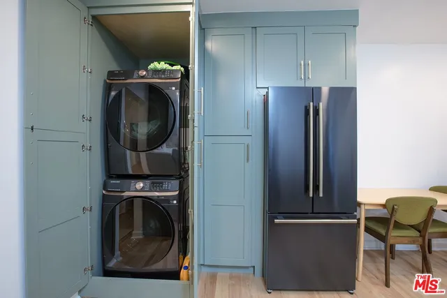 a kitchen with stainless steel appliances granite countertop sink refrigerator dining table and chairs