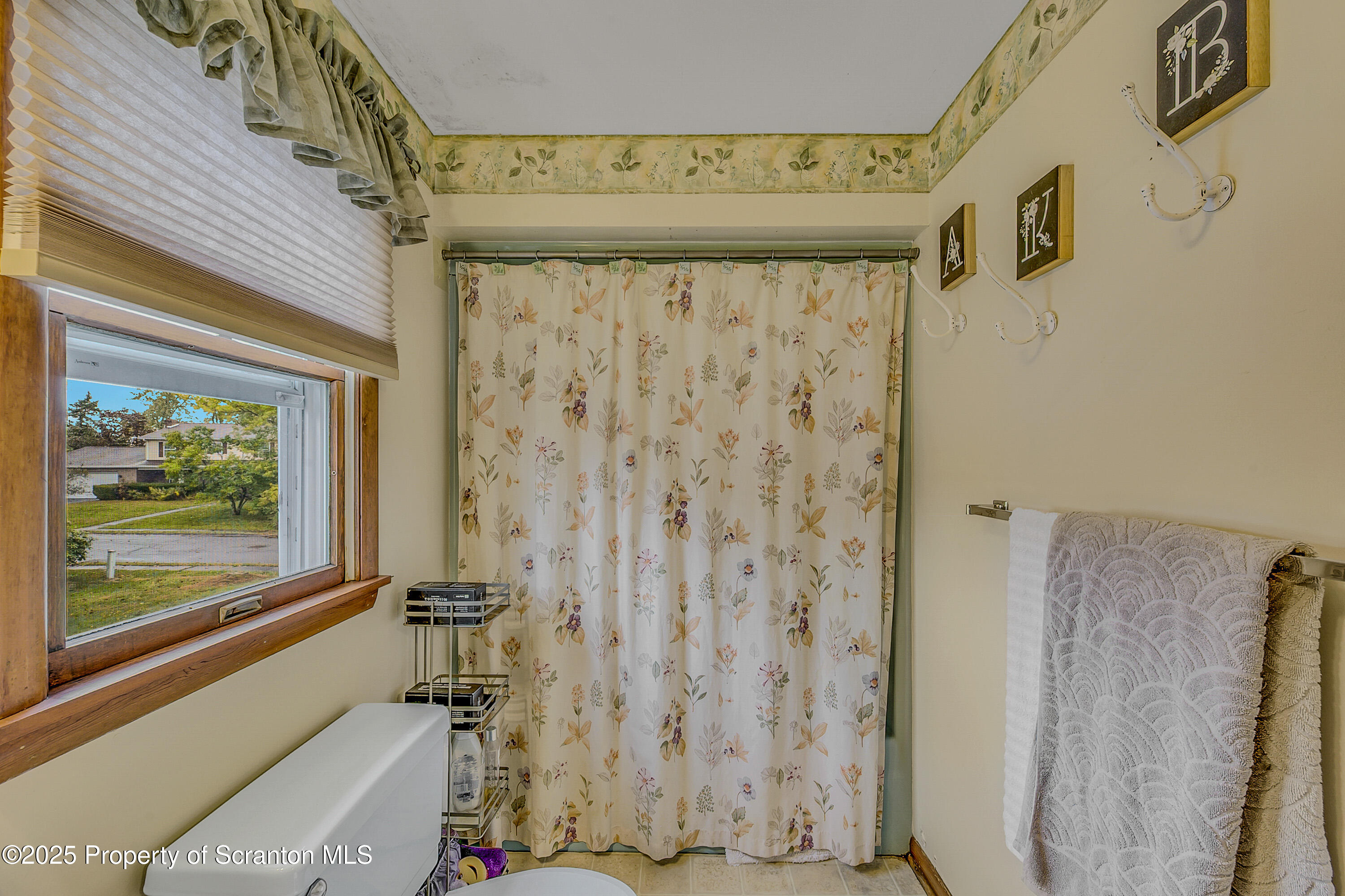 1002 Pheasant Run Road Clarks Summit, PA 18411 - Photo 44 of 53 a bathroom with a shower curtain and a window
