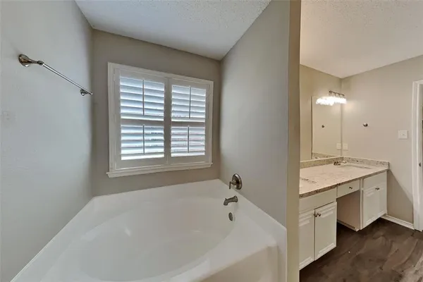 a spacious bathroom with a granite countertop tub sink and mirror