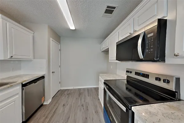 a kitchen with stainless steel appliances and wooden cabinets