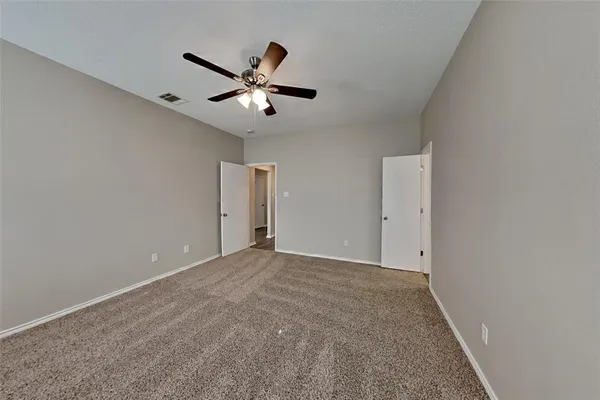 a view of an empty room with a ceiling fan
