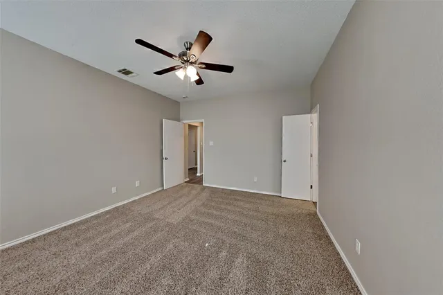 a view of an empty room with a ceiling fan