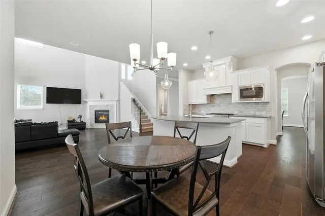 a kitchen with stainless steel appliances kitchen island granite countertop a sink a stove a dining table and chairs