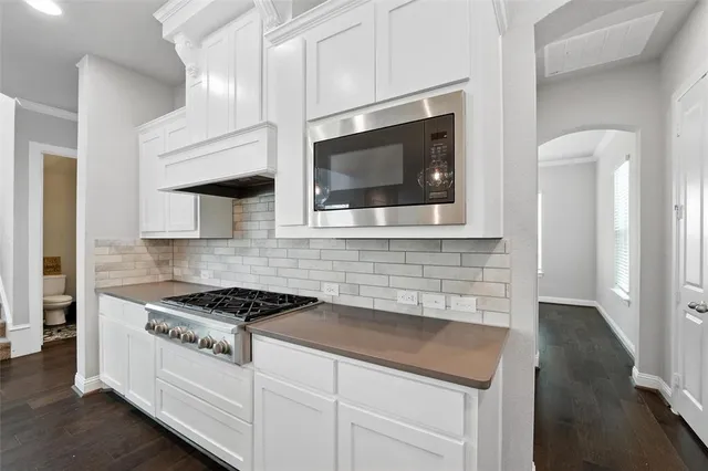 a kitchen with stainless steel appliances granite countertop a stove and a microwave