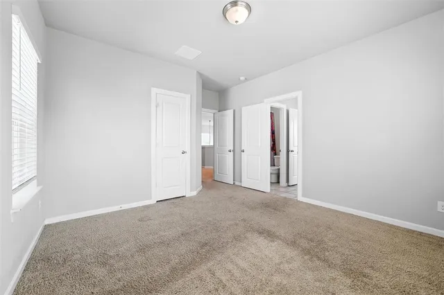 an empty room with a window and a ceiling fan