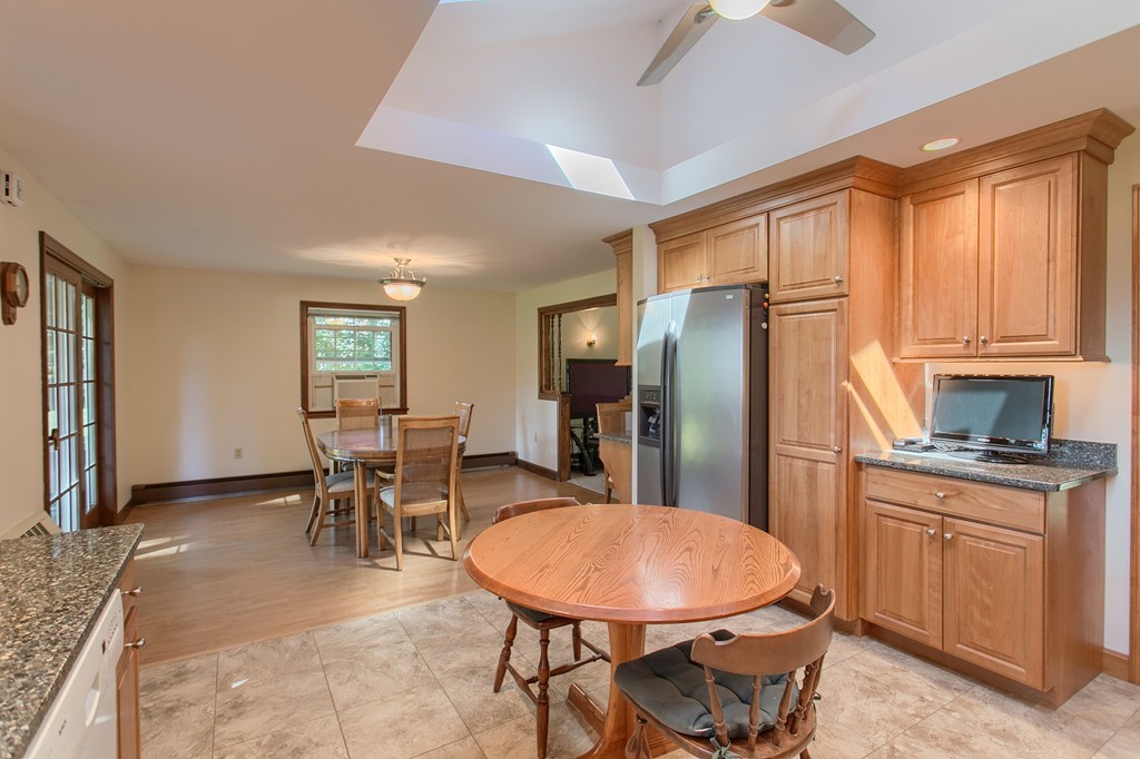 24 Newton Road Westminster, MA 01473 - Photo 6 of 30 a kitchen with stainless steel appliances granite countertop a refrigerator a sink a stove a dining table and chairs with wooden floor