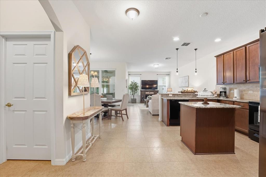 11675 Snail Kite Way Windermere, FL 34786 - Photo 12 of 46 a kitchen with stainless steel appliances kitchen island granite countertop a stove top oven a sink a dining table and chairs