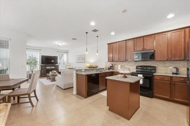 a kitchen with a sink a counter top space appliances and cabinets