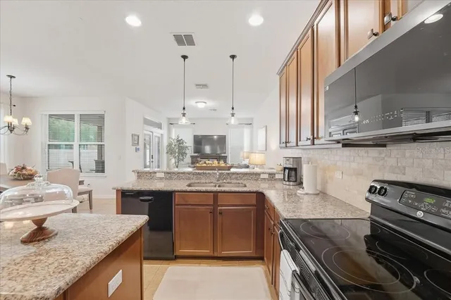 a kitchen with stainless steel appliances granite countertop a sink stove and cabinets