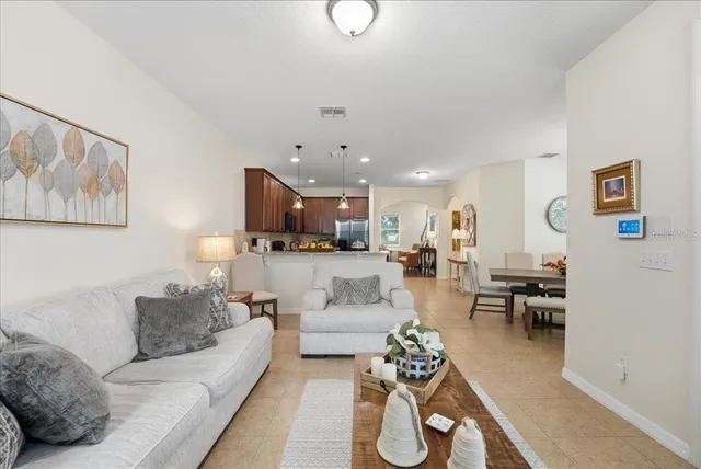 a living room with furniture kitchen view and a dining table