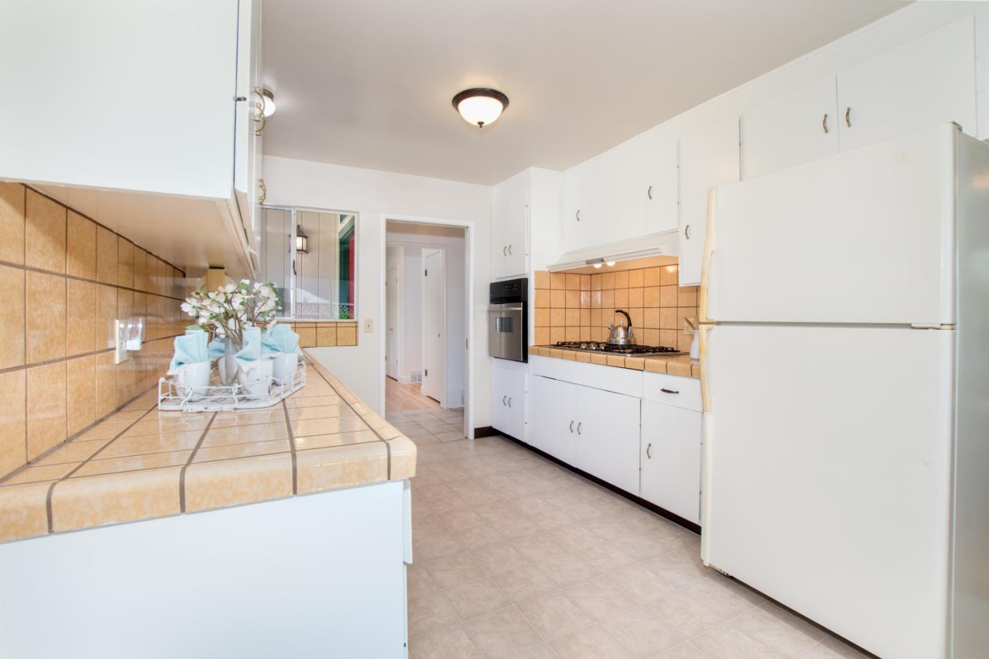 754 Ridge Rd. Santa Clara, CA 95051 - Photo 14 of 25 a view of a kitchen with refrigerator and white cabinets