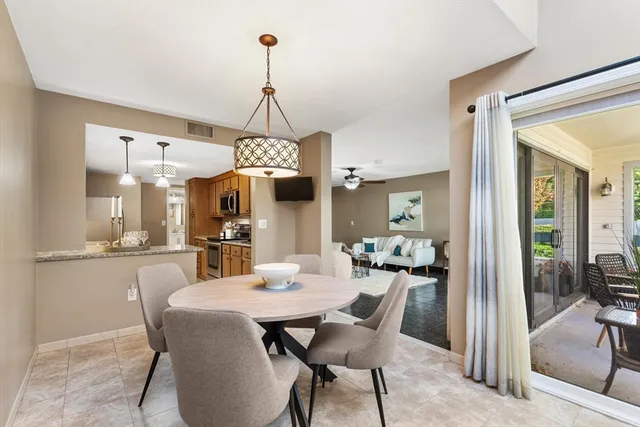 a view of a dining room and livingroom with furniture wooden floor a chandelier