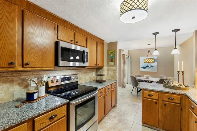 a kitchen with stainless steel appliances granite countertop a sink stove and cabinets