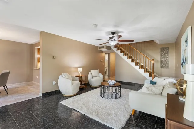 a living room with furniture and stairs