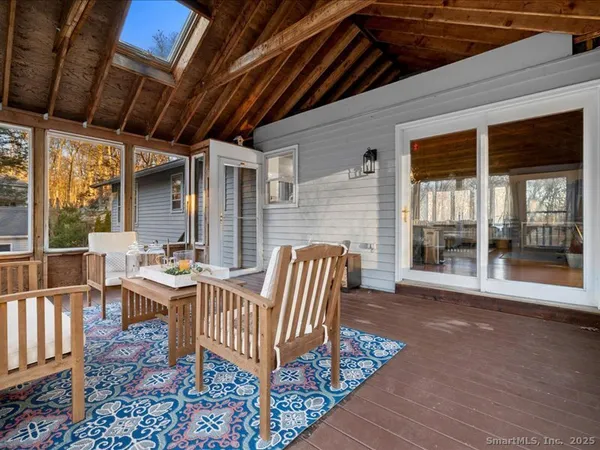 a view of a deck with table and chairs with wooden floor and fence