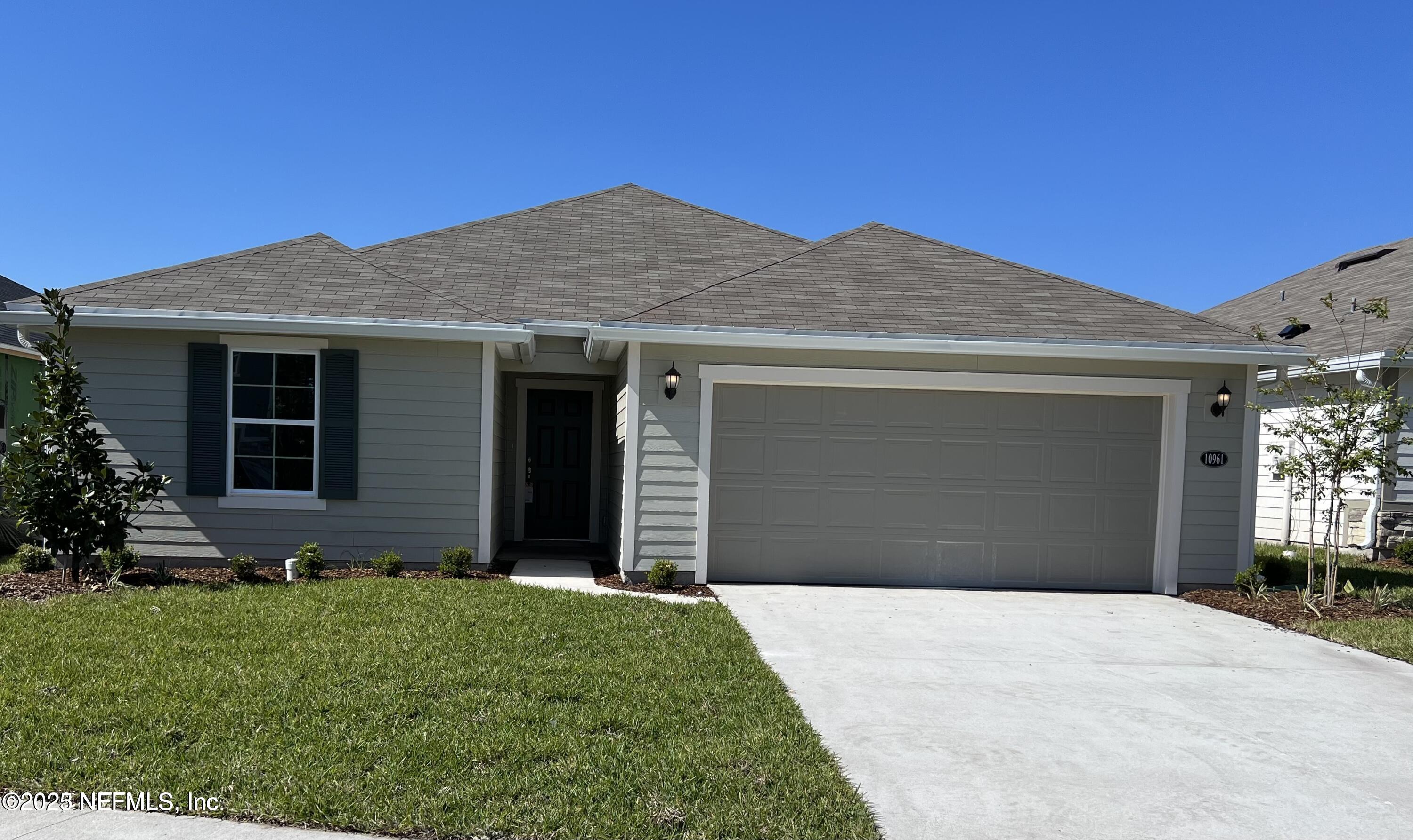 10961 Stapleton Drive Jacksonville, FL 32222 - Photo 2 of 13 a front view of a house with garden