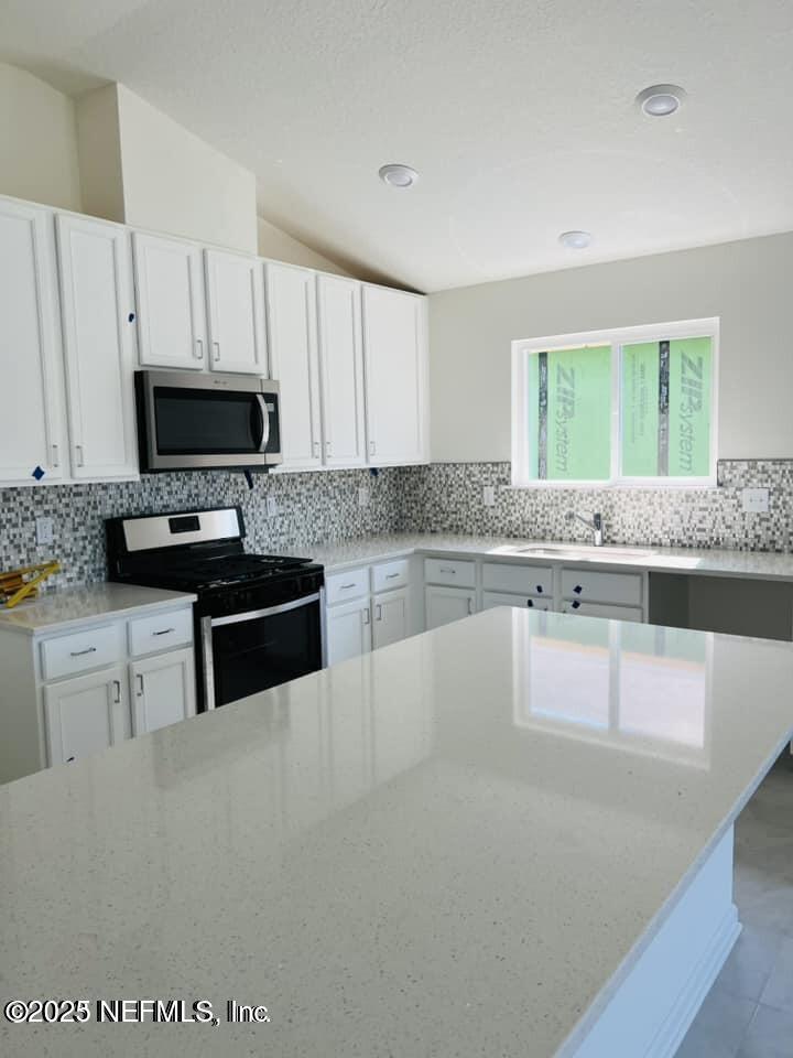 10961 Stapleton Drive Jacksonville, FL 32222 - Photo 3 of 13 a kitchen with granite countertop a stove a sink and a microwave