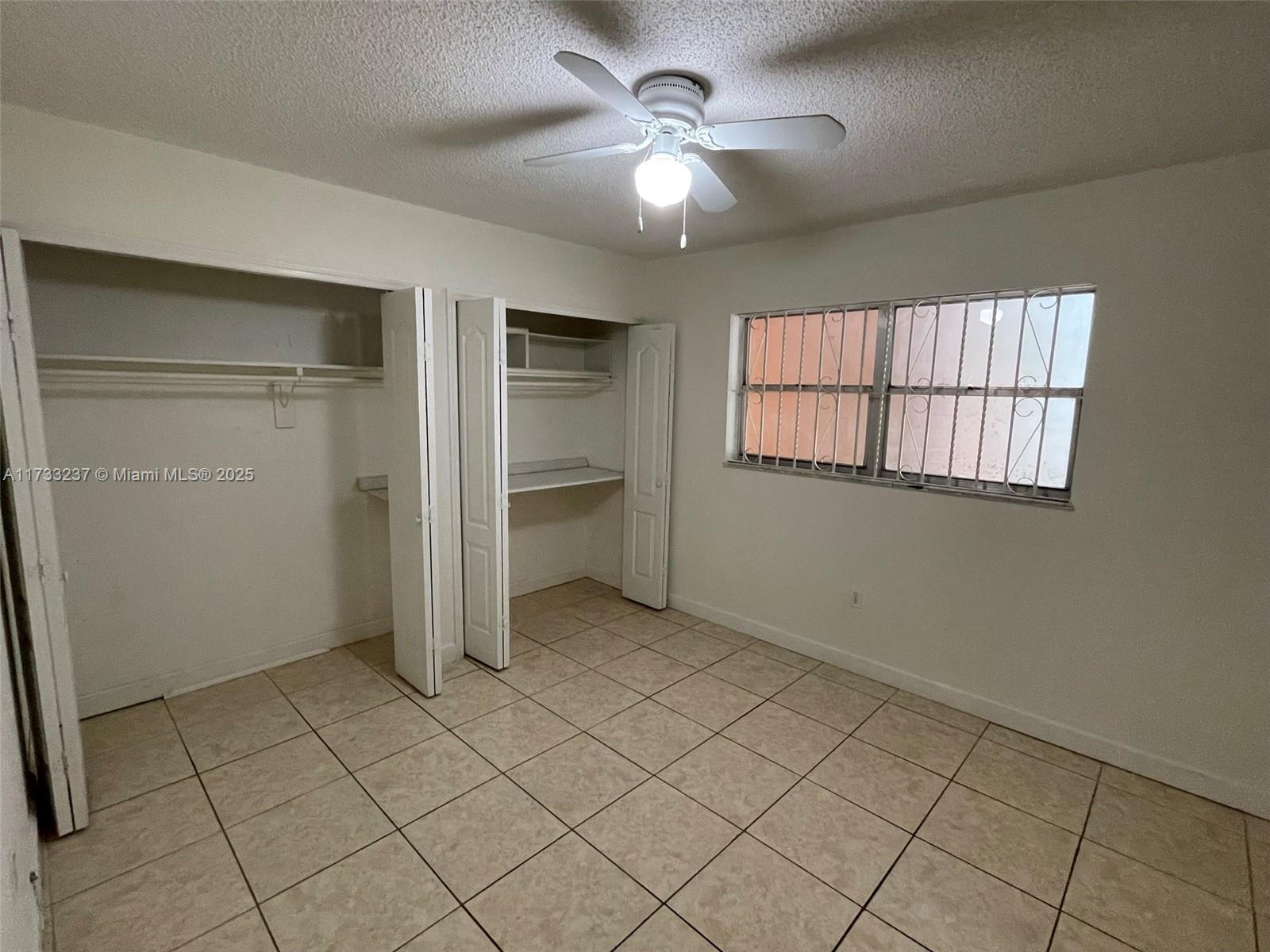 1950 West 54th Street, Unit 112 Hialeah, FL 33012 - Photo 14 of 27 an empty room with chandelier fan and windows